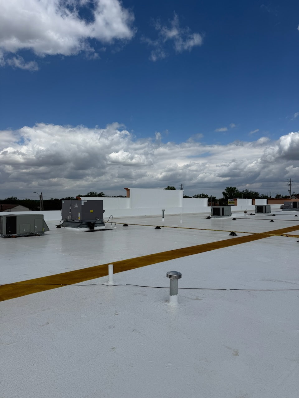 White reflective commercial roof coating applied to a flat retail rooftop in Northeast Ohio