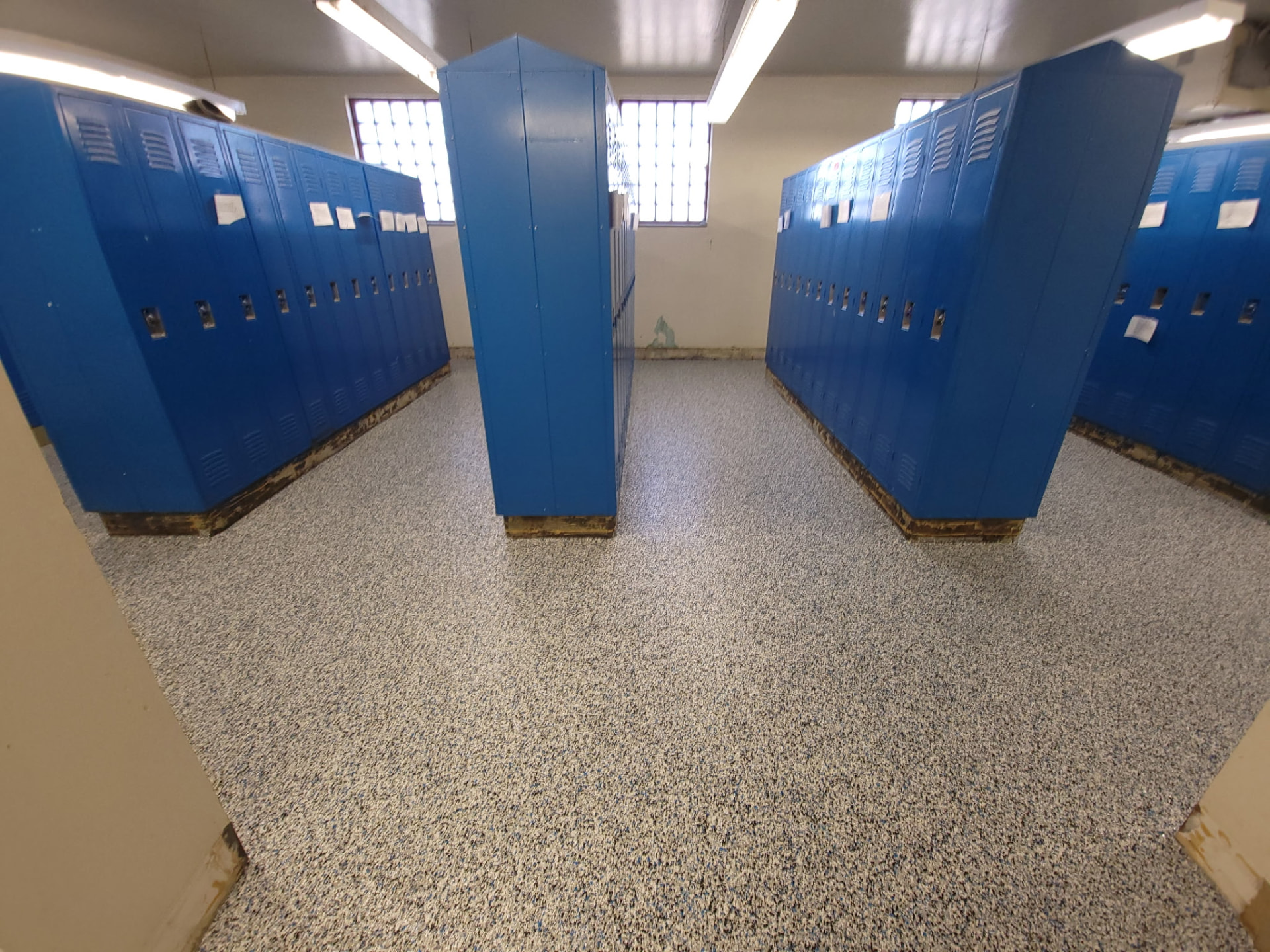 Tan and grey flake epoxy floor in a Summit County school locker room